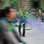 Woman spins bike with green and purple smoke effects
