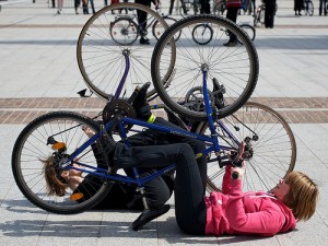 two particpants lie on their backs holding bikes as if riding upside down