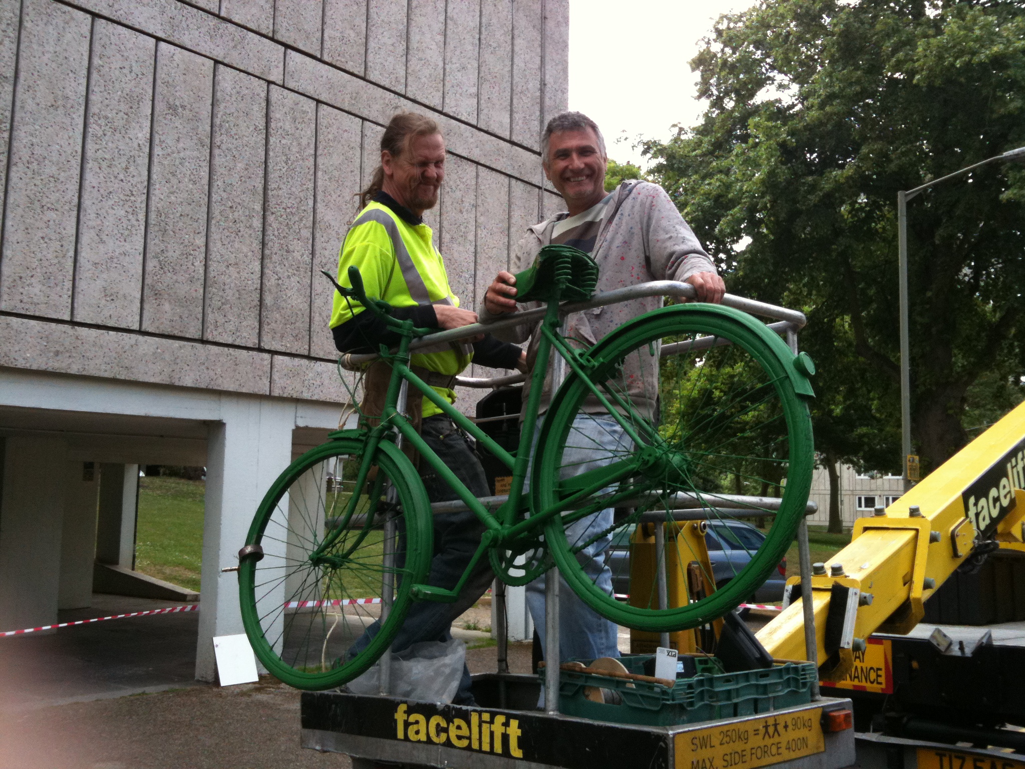 Performance Parking Technicians in cherry picker with a green bike