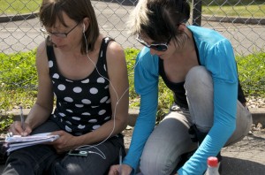 Image of Janine and Karen share ipod headphones, making notes on the show music