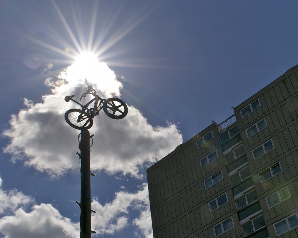 Silhouetted bike sitting atop a telegraph pole with sunburst