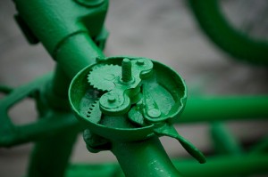 close up of the inner workings of a bicycle bell, painted green