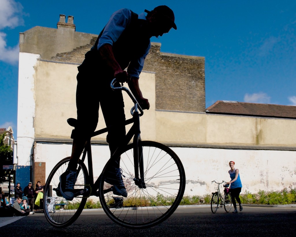 Rider prepares to bunny hop on his bike, sister looks on