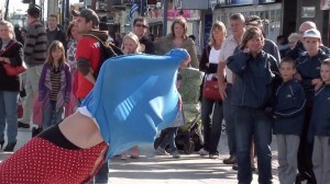 girl pulls dress over her head and pulls faces through the material to the crowd