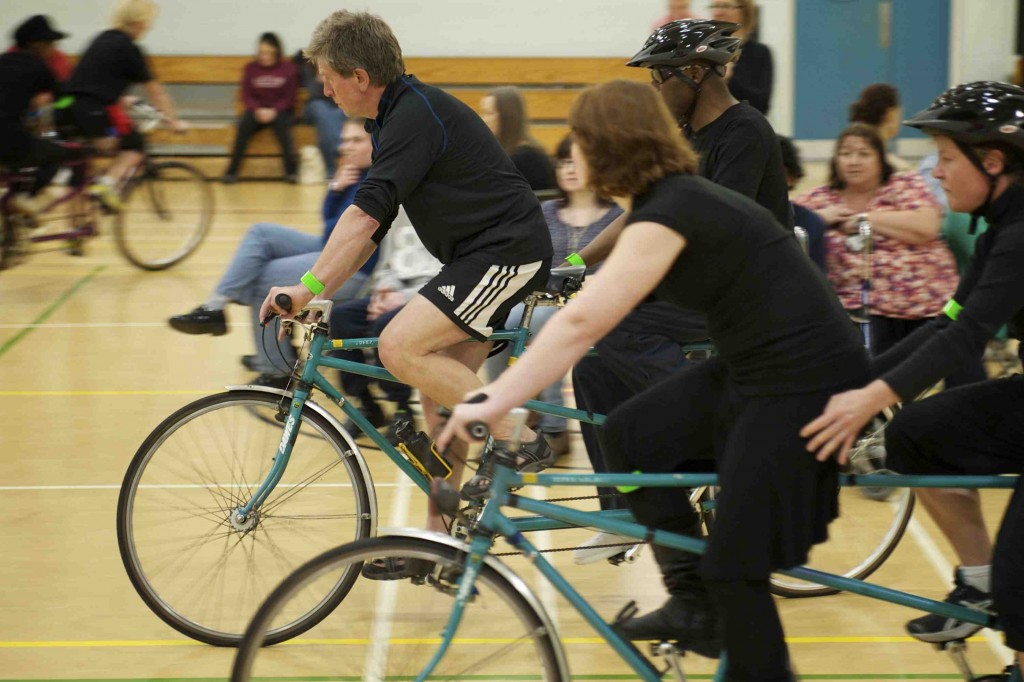 Tandems ride in a huge circle around audience members in the centre of the space