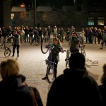 performers hold their bikes on the back wheels, during the night show